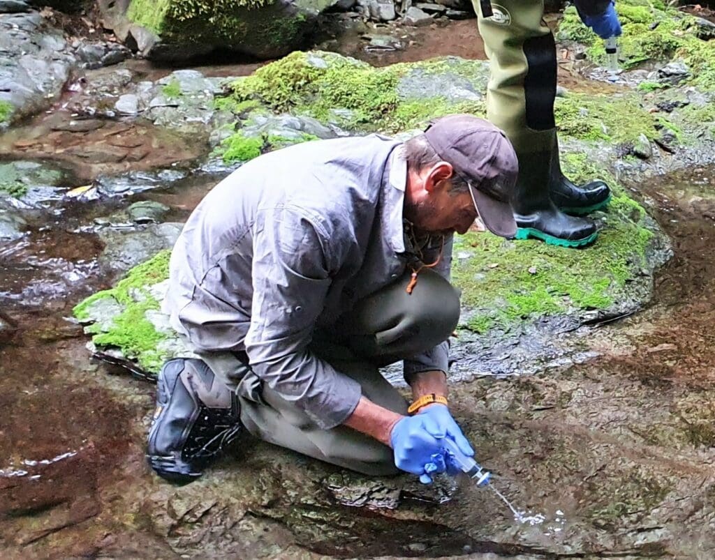 Scientist sampling water in river